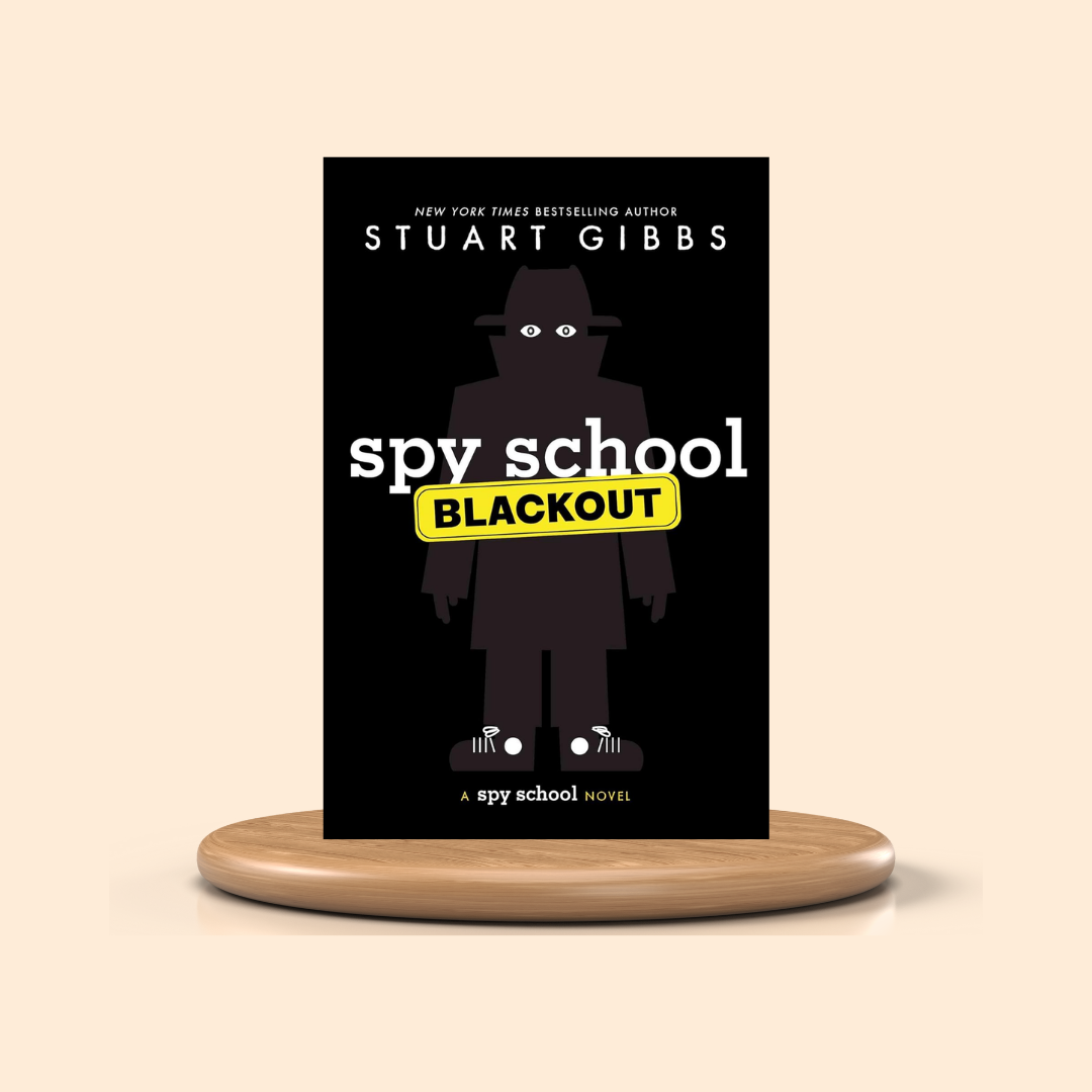 Book cover of 'Spy School: Blackout' by Stuart Gibbs on a stand with a beige background